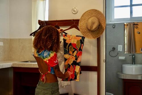 Una donna sta appendendo una camicia in una cucina di Golden Paradise Town a Isola Holbox