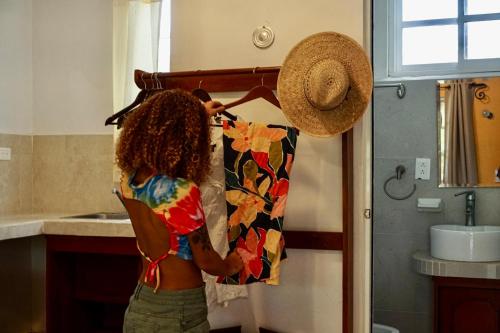 a woman is hanging a shirt in a kitchen at Golden Paradise Town in Holbox Island