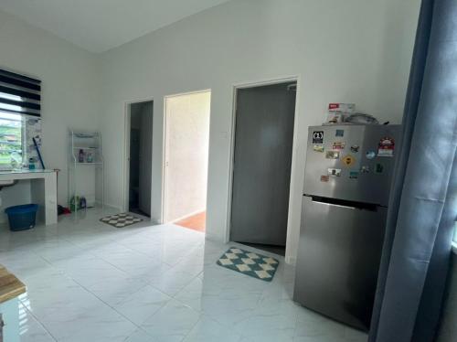 a kitchen with a stainless steel refrigerator in a room at Inap desa homestay batu buruk in Kuala Terengganu
