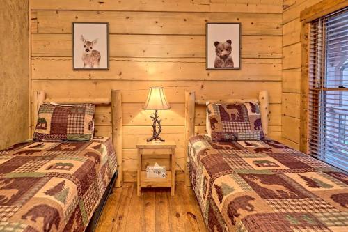 two beds in a room with wooden walls at Ruby River Lodge in Ellijay