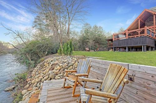 two chairs sitting on a dock next to a house at Ruby River Lodge in Ellijay