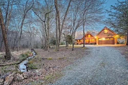 a home in the woods with a road leading to it at Ruby River Lodge in Ellijay