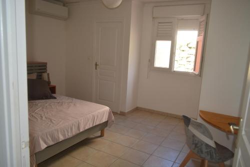 1 dormitorio con cama, ventana y escritorio en TI'CARAIBES, en Les Trois-Îlets