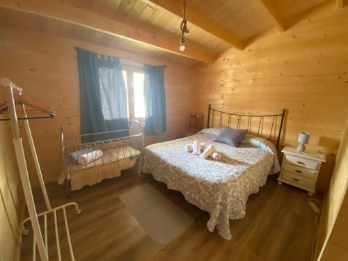 1 dormitorio con 1 cama en una cabaña de madera en CABAÑA RURAL El MOLINO - Jacuzzi, en La Cimada