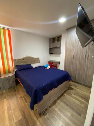 1 dormitorio con 1 cama y TV de pantalla plana en MINISUITES Centro Pasto en Pasto