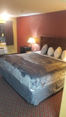 Una cama grande en una habitación de hotel con almohadas. en OSU King Bed Hotel Room 111 Booking, en Stillwater