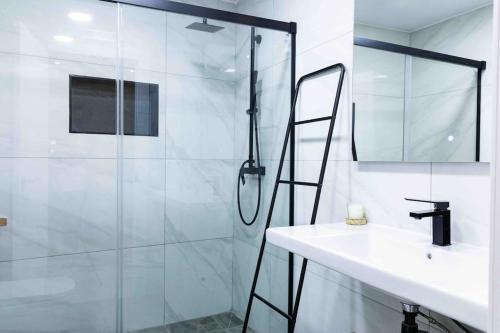 Un baño con ducha de cristal y lavabo. en Modern 3-bed apartment in heart of torremolinos, en Torremolinos
