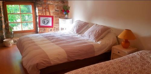 a bedroom with a bed and a lamp and a window at chambre familiale 4 pers SDB partagée sans TV in Le Saint