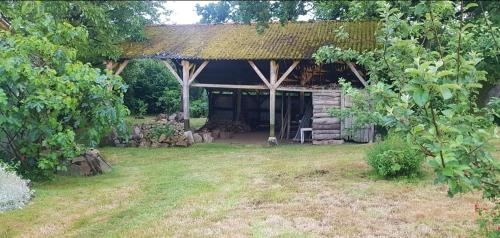 a cabin with a grass roof in a yard at chambre familiale 4 pers SDB partagée sans TV in Le Saint