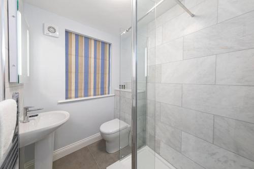 a white bathroom with a toilet and a sink at Vine Cottage in Hexham