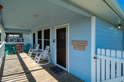 a front porch of a blue house with a sign on the door at Lunasea Haven in Rockport