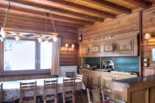 a dining room with a table and a kitchen at La Ribambelle in Chamonix-Mont-Blanc