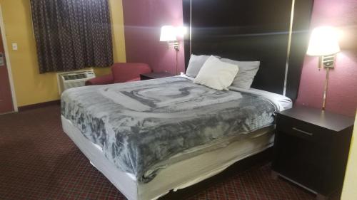 una habitación de hotel con una cama y una silla en OSU King Bed Hotel Room 111 Booking, en Stillwater