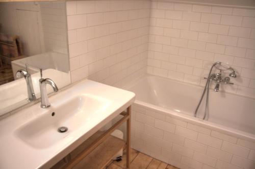 a white bathroom with a sink and a tub at La Ribambelle in Chamonix-Mont-Blanc
