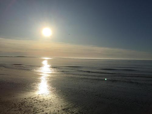 a beach with the sun rising over the ocean at Riverton Cottage 2 Bedroom Close to beach in Riverton