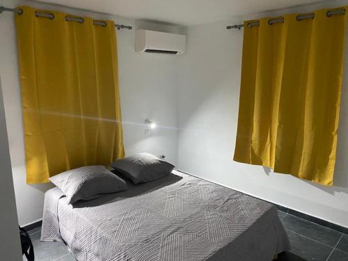 a bedroom with a bed and two yellow curtains at Domaine de Dugay in Beauregard