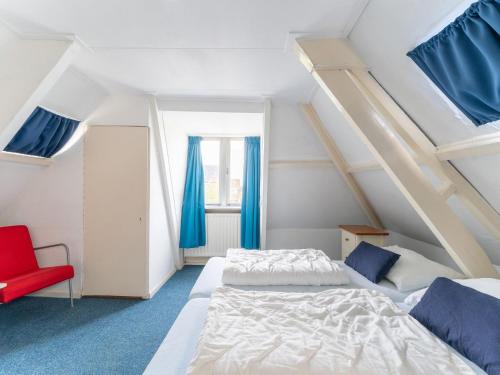 a bedroom with two beds and a red chair at Waterside Escape with Private Jetty in Heeg