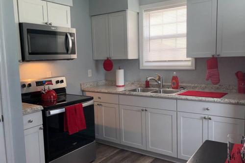 uma cozinha com um lavatório, um fogão e um micro-ondas em Lovely Two Bedroom Duplex Near Buckroe Beach em Hampton
