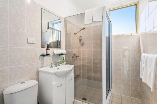 a bathroom with a toilet and a sink and a shower at Little Hut Unit 3 20 Kurrawa Close in Nelson Bay