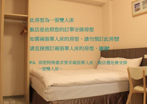 Dormitorio con cama con escritura china en la pared en Sunnyside Hotel, en Kaohsiung