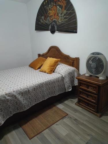 a bedroom with a bed and a table with a fan at Be like home Texas in Alcalá de Henares