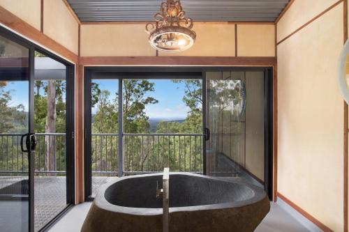 a bath tub in a room with a window at Gold Coast Tree Houses in Neranwood