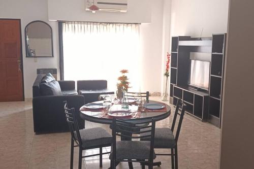 uma sala de estar com uma mesa e cadeiras e um sofá em América 1 em Villa Luzuriaga