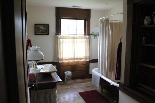 um quarto com uma janela e uma mesa com um candeeiro em Upstairs Historic 1 Bedroom 1 Bath Suite with Mini-Kitchen, Porch & River Views em Elkins