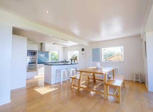 a kitchen and dining room with a wooden table and chairs at Palm Ridge - near Onetangi & Palm Beach in Palm Beach