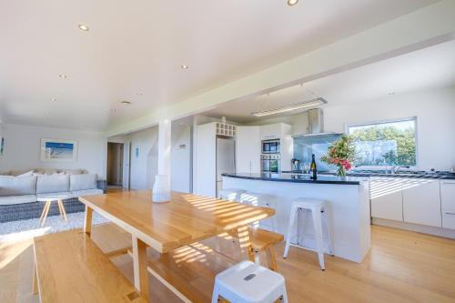 a kitchen and living room with a wooden dining table at Palm Ridge - near Onetangi & Palm Beach in Palm Beach