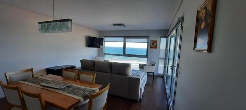 a living room with a couch and a table with a dining room at Ventana al Golfo in Puerto Madryn