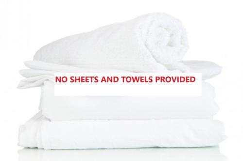 a pile of towels with a sign that reads no sheets and towels provided at Sunnie Belle, 2,3 Victoria Parade - Unit with water views and air conditioning in Nelson Bay