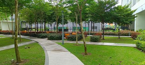 a walkway in a park with trees and a building at Peace home 03 in Cyberjaya