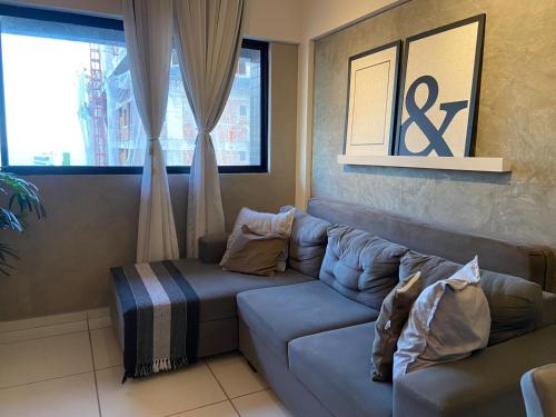 a living room with a couch and a window at QUARTO/SALA COM VISTA P/ O MAR DE PAJUÇARA in Maceió