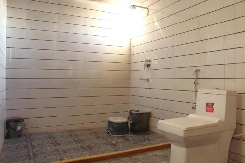 a bathroom with a toilet and two trash cans at Golden Empire luxury Resort in Sām