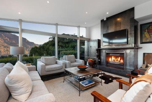 a living room with a couch and a fireplace at Remarkable Escape for 8 in Queenstown