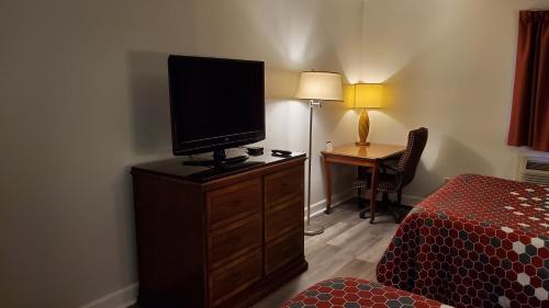 a bedroom with a television on a dresser with a bed at Stonewood Inn & Suites of Carrollton - Smithfield in Carrollton