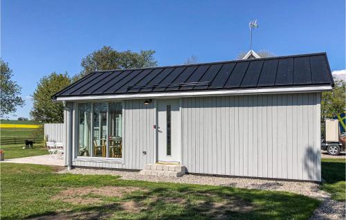 a small white building with a solar roof at Lovely Home In Skivarp With Wifi in Skivarp