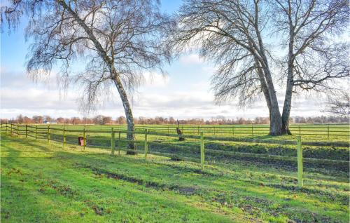 a fence in a field with two trees at Lovely Home In Skivarp With Wifi in Skivarp