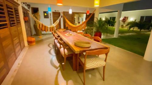 a dining room with a wooden table and chairs at Villa Paririö in Canoa Quebrada