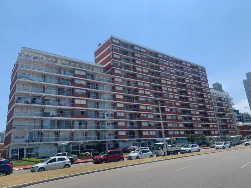 a large building with cars parked in a parking lot at Casa Nostrum Priceless View Central Location 3BR 3BA in Punta del Este