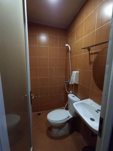 La salle de bains est pourvue de toilettes et d'un lavabo. dans l'établissement Hotel Aleander, à Jakarta