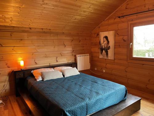 a bedroom with a bed in a log cabin at Gîte Saint-Rémy-en-Rollat, 5 pièces, 6 personnes - FR-1-489-370 in Saint-Rémy-en-Rollat