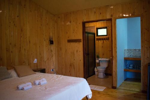 ein Schlafzimmer mit Bett und ein Badezimmer mit Toilette in der Unterkunft Cabañas Lys in Monteverde Costa Rica