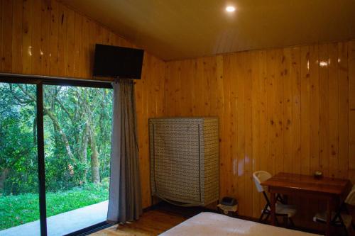 a bedroom with a bed and a window and a desk at Cabañas Lys in Monteverde Costa Rica