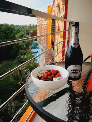 a bowl of strawberries and a bottle of beer on a table at Квартира in Mai Khao Beach