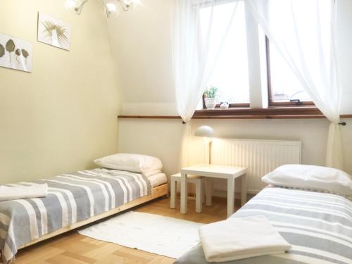 2 łóżka w małym pokoju z oknem w obiekcie Apartament Blanko w mieście Białystok