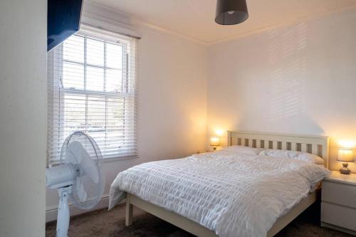 a white bedroom with a bed and a fan at No6 - Beverley - Elegant Townhouse - Central location in Beverley