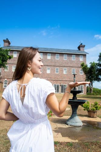 a woman in a white dress standing in front of a building at 墾丁勿忘我城堡莊園 in Hengchun
