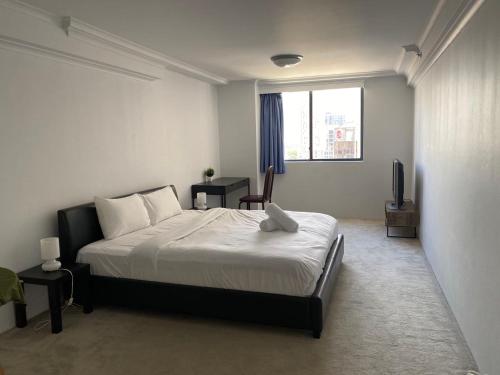 a bedroom with a bed and a television in it at KozyGuru / Haymarket SYD / Cozy Warm / 1 Bed APT / NHA317-546B in Sydney